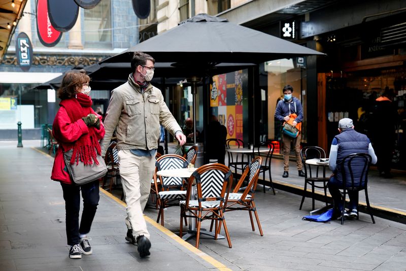 &copy; Reuters. People walk past a cafe after the coronavirus disease (COVID-19) restrictions were eased for the state of Victoria, in Melbourne