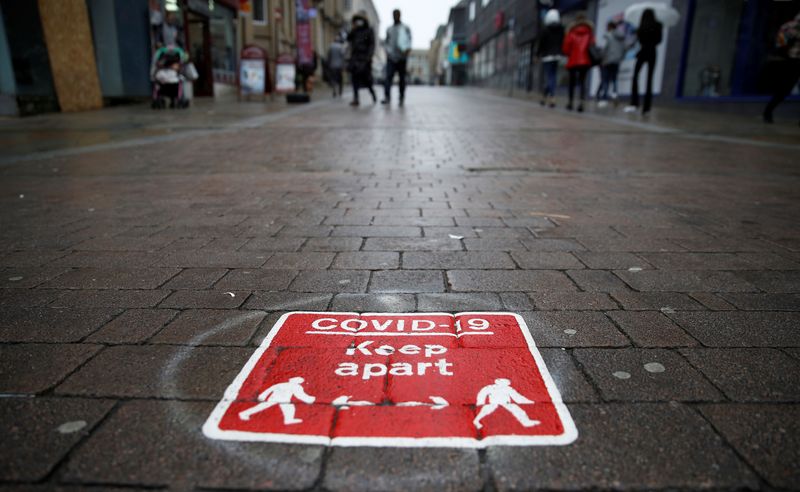 &copy; Reuters. People walk past a social distancing marker following the outbreak of the coronavirus disease (COVID-19) in Bolton, Britain