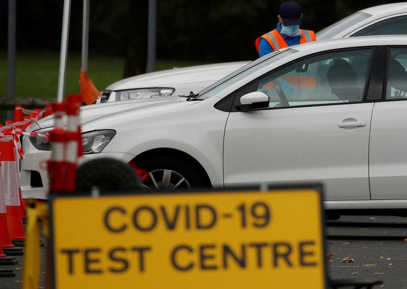 &copy; Reuters. An NHS test and trace worker talks to a driver at a drive-through testing centre following the outbreak of the coronavirus disease (COVID-19) in Bolton, Britain