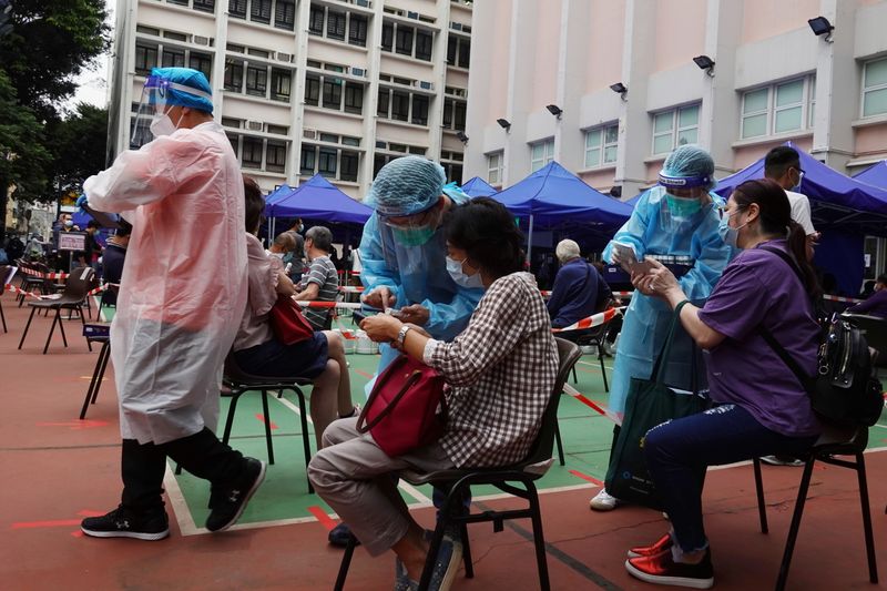 &copy; Reuters. Profissionais de saúde atendem pacientes em centro comunitário de testes de detecção de Covid-19 em Hong Kong