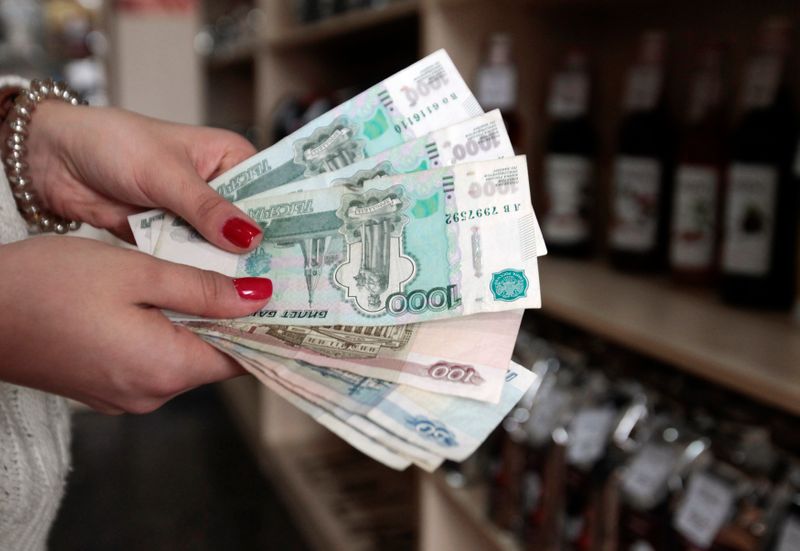 &copy; Reuters. A coffee shop vendor demonstrates Russian rouble banknotes in Stavropol