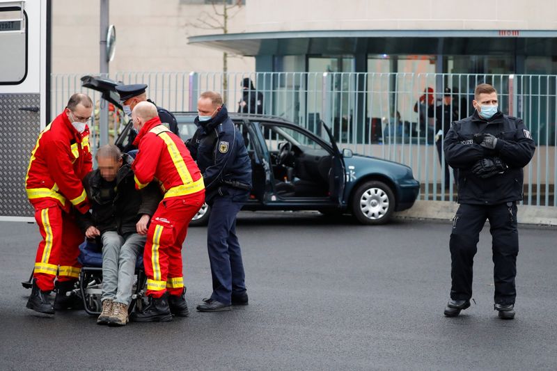 © Reuters. Los bomberos atienden a un hombre que estrelló su coche contra la puerta principal de la cancillería de Berlín, la oficina de Angela Merkel. Berlín, Alemania, 25 de noviembre de 2020. REUTERS/Fabrizio Bensch