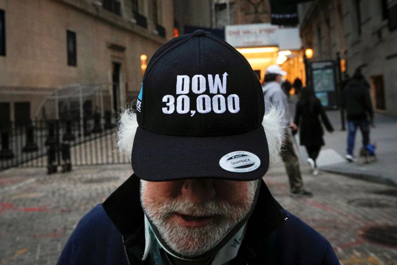 © Reuters. Trader Peter Tuchman wears a DOW 30,000 hat as he greets friends outside the New York Stock Exchange (NYSE) in New York