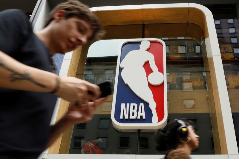 &copy; Reuters. The NBA logo is displayed as people pass by the NBA Store in New York