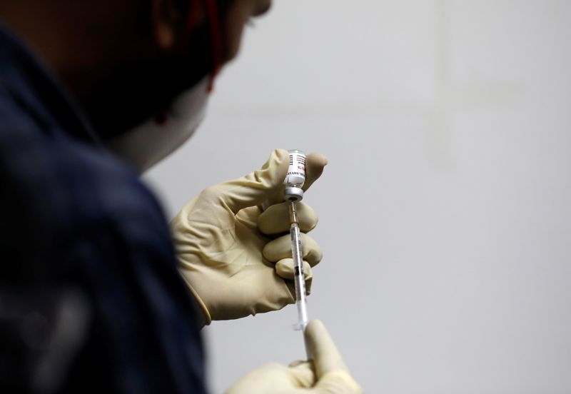 &copy; Reuters. A medic fills a syringe with COVAXIN, an Indian government-backed experimental COVID-19 vaccine, before administering it to a health worker during its trials, in Ahmedabad