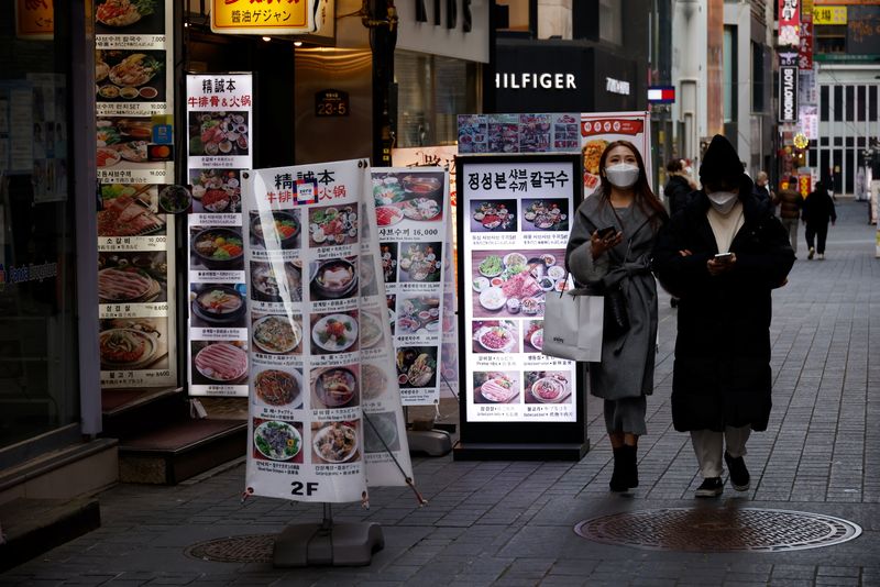 &copy; Reuters. Mulheres caminham em distrito comercial vazio de Seul em meio à pandemia de Covid-19