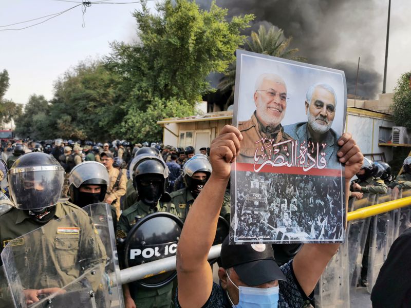 &copy; Reuters. FILE PHOTO: A supporter of Hashid Shaabi (Popular Mobilization Forces) holds a picture of late Iran&apos;s Quds Force top commander Qassem Soleimani and Iraqi militia commander Abu Mahdi al-Muhandis who were killed in a U.S. airstrike during a protest in 