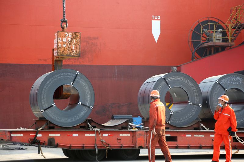 © Reuters. Workers load steel products for export to a cargo ship at a port in Lianyungang