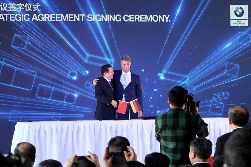 © Reuters. FILE PHOTO: Harald Krueger, BMW Chief Executive hugs Chen Qiufa, Communist Party Secretary of Liaoning province for a photo during a signing ceremony inside the BMW Brilliance Plant Tiexi, in Shenyang