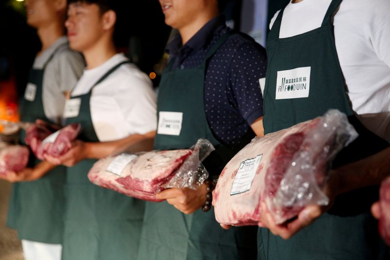 &copy; Reuters. FILE PHOTO: Employees of Shanghai All Food Win Co., Ltd. pose with beef at a storage area near the Pudong International Airport in Shanghai
