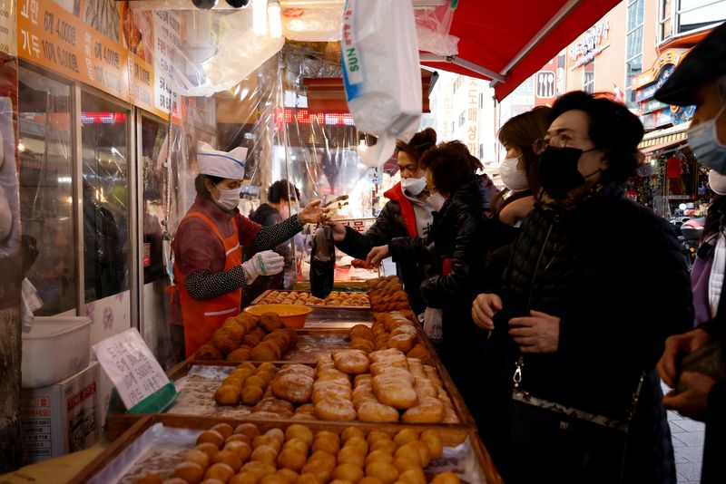 &copy; Reuters. FILE PHOTO: Women buy donuts at a traditional market amid the coronavirus disease (COVID-19) pandemic in Seoul