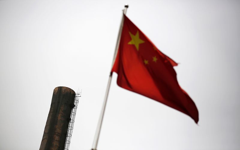 &copy; Reuters. A Chinese national flag is seen in front of a chimney of a heat supply plant in Beijing