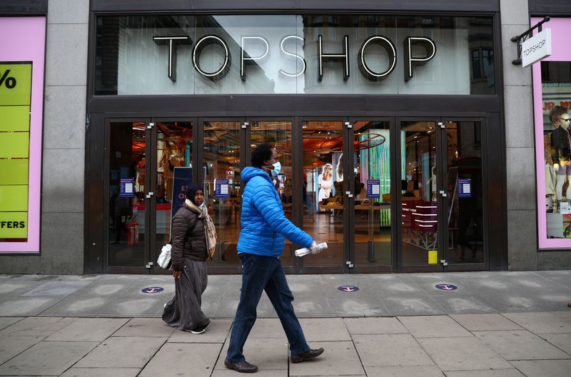 © Reuters. FILE PHOTO: People walk past an entrance to the Topshop store at the Oxford Street, in London