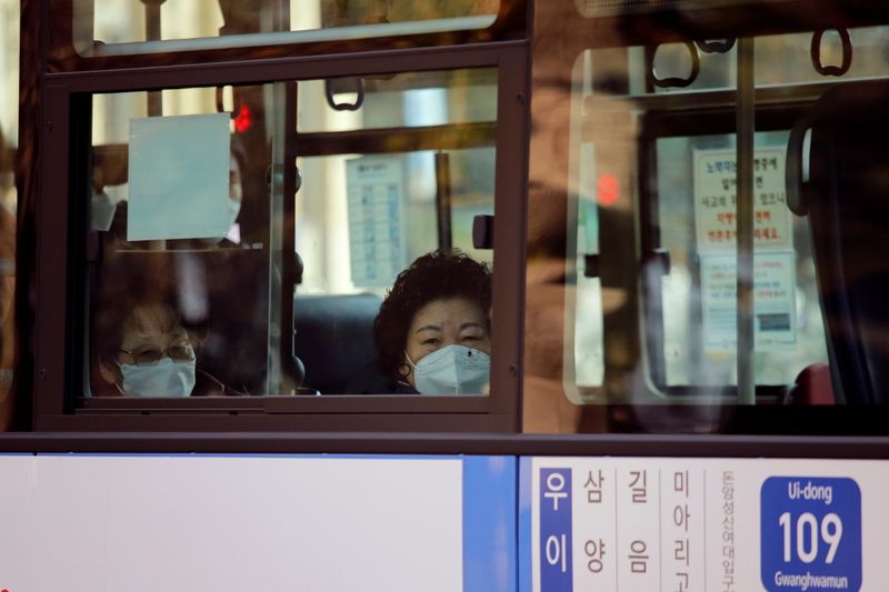 &copy; Reuters. Sul-coreanos em ônibus pelas ruas de Seul