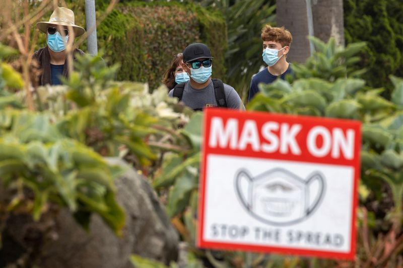 &copy; Reuters. People wear masks as they walk along the side walk during the outbreak of the coronavirus disease in California