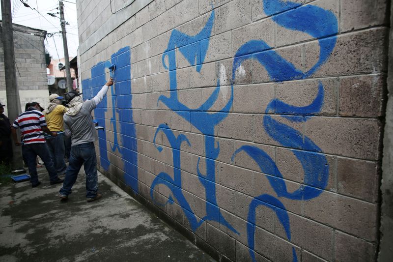 &copy; Reuters. FILE PHOTO: Police officers paint off a graffiti related to the MS-13 gang at La Vega neighborhood in San Salvador, El Salvador