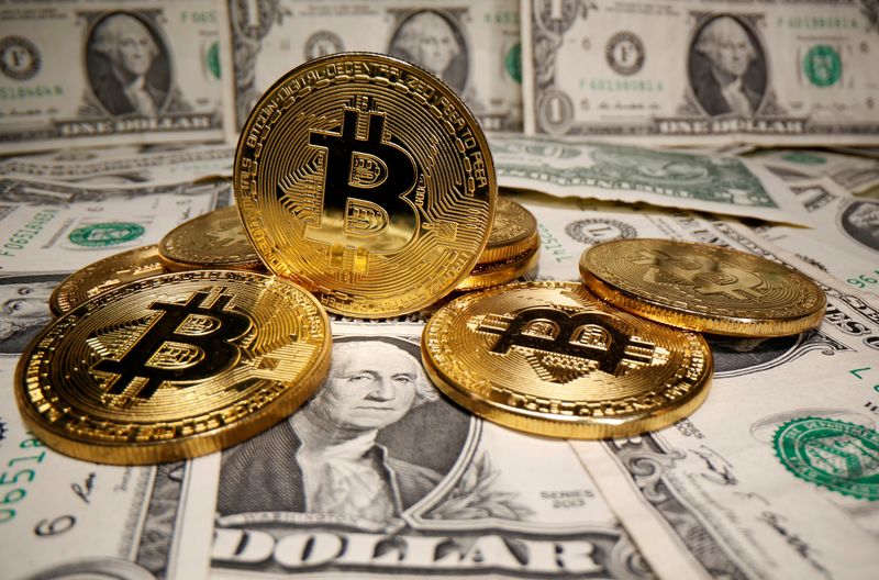 © Reuters. FILE PHOTO: Representations of virtual currency Bitcoin are placed on U.S. Dollar banknotes