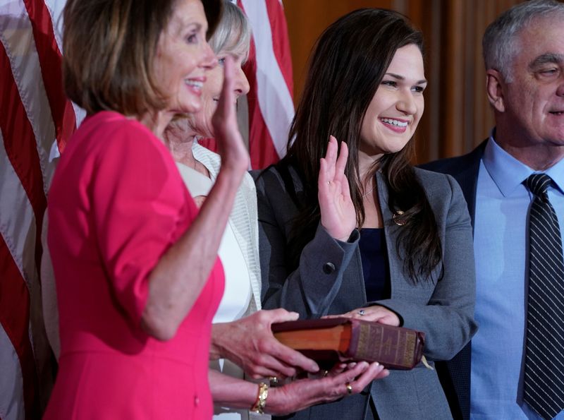 © Reuters. Rep. Abby Finkenauer (D-IA) poses with Speaker of the House Nancy Pelosi (D-CA) for a ceremonial swearing-in picture on Capitol Hill in Washington