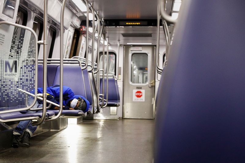 &copy; Reuters. A person rests on a Washington Metro subway car wearing a face mask, following Mayor Muriel Bowser&apos;s declaration of a state of emergency due to the coronavirus disease (COVID-19) in Washington