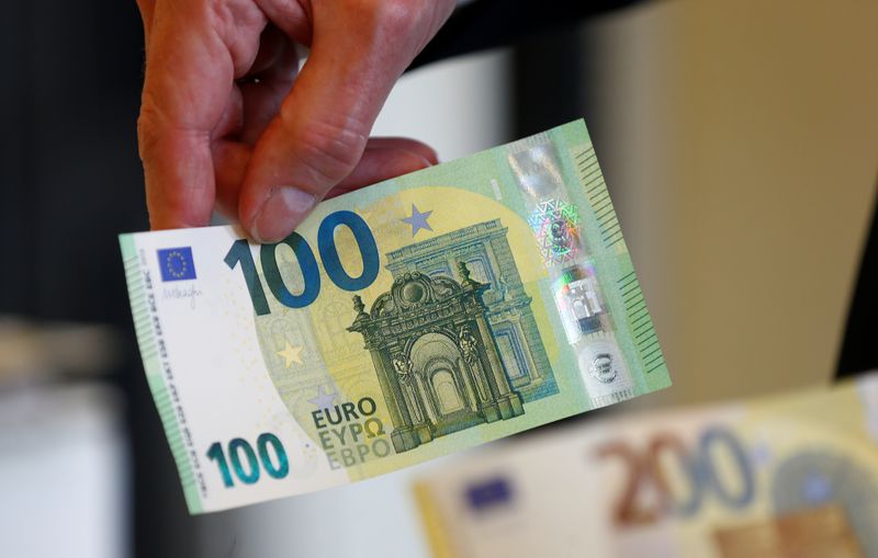 © Reuters. European Central Bank (ECB) Banknotes Director Ton Roos shows the new 100 euro banknote in the secretive vaults inside the Bank of Italy in Rome