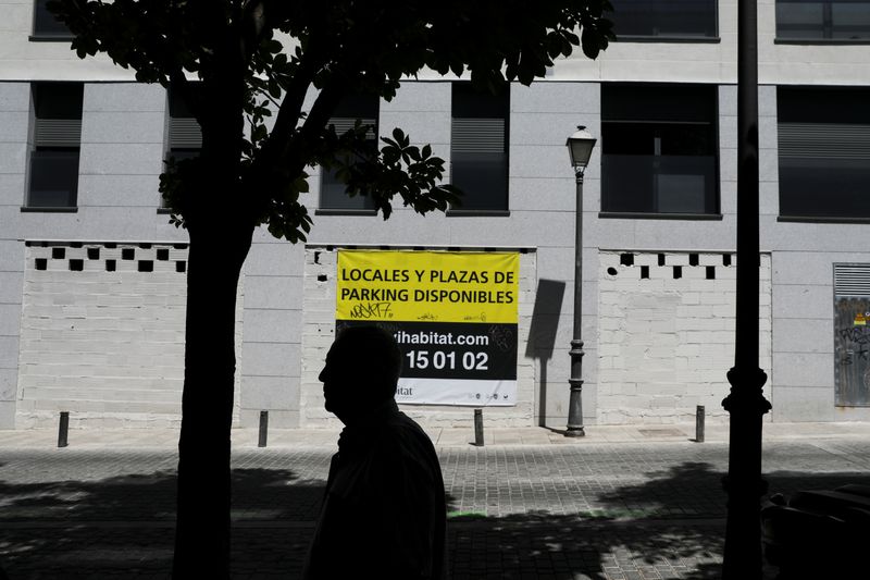 &copy; Reuters. FILE PHOTO: A man walks past a sign that reads &quot;Properties and parking available&quot; on the wall of an apartment complex in Madrid