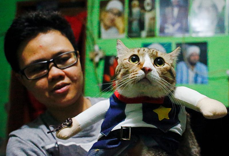 &copy; Reuters. Risma Sandra Irawan, 31, carries her cat wearing a cosplay costume, in Jakarta