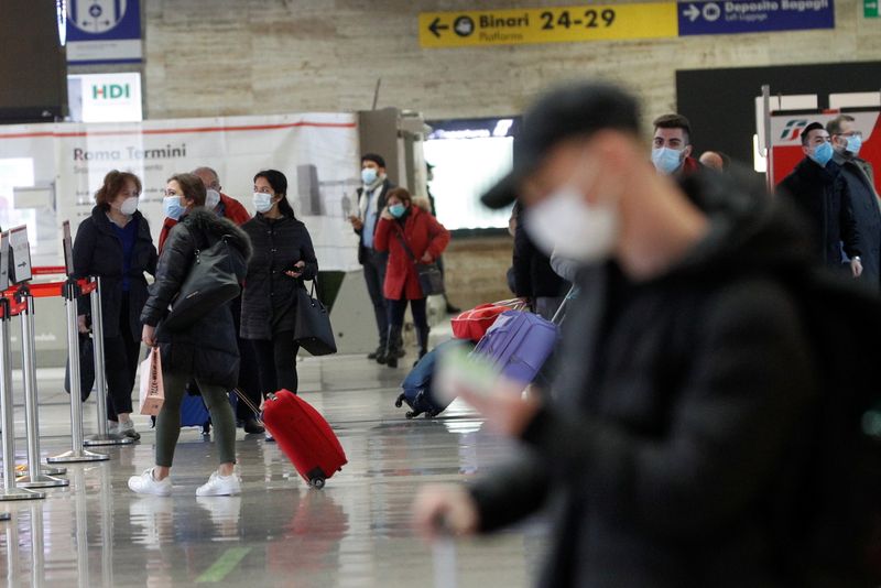 © Reuters. Pessoas usam máscaras de proteção em estação ferroviária em Roma