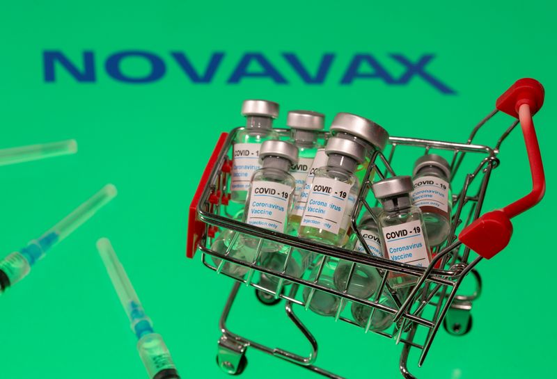 &copy; Reuters. FOTO DE ARCHIVO: Un carrito de la compra en miniatura cargado con viales etiquetados &quot;COVID-19 - Vacuna coronavirus&quot; y varias jeringas médicas sobre el logotipo de Novavax