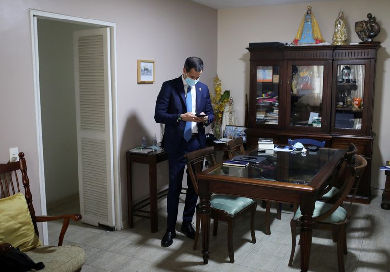 &copy; Reuters. FILE PHOTO: Venezuela&apos;s opposition leader Juan Guaido uses his mobile phone before an interview with Reuters in Caracas