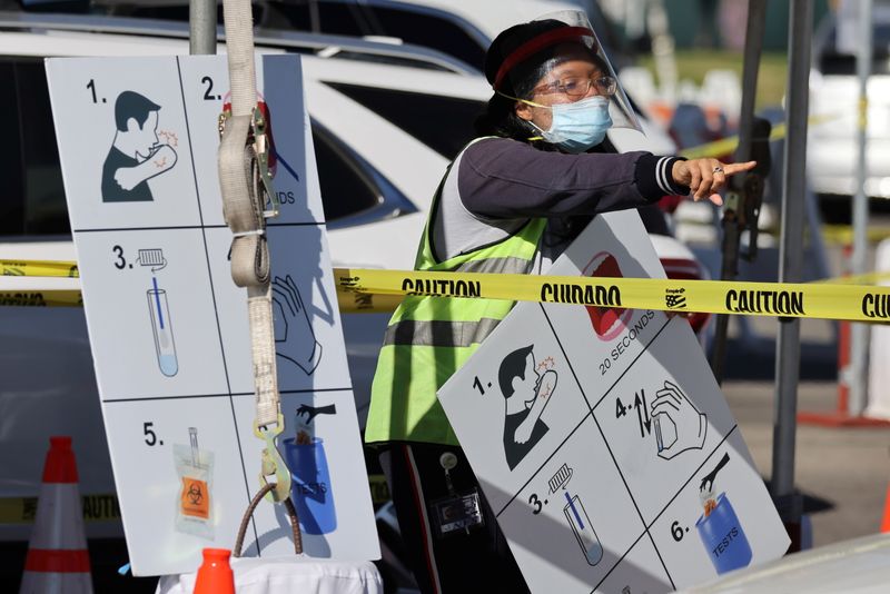 © Reuters. A worker gives instructions to drivers in line for novel coronavirus tests in Los Angeles