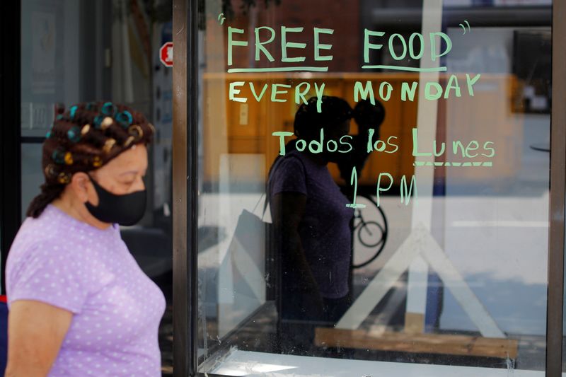 © Reuters. FILE PHOTO: A pedestrian passes a notice for a food pantry in Chelsea