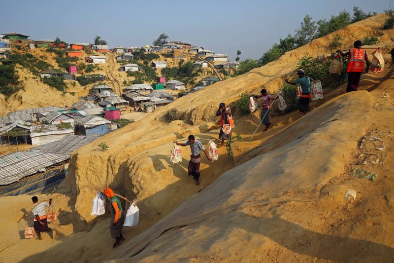 &copy; Reuters. FILE PHOTO: Rohingya refugees carry bricks to a construction site at the Balukhali camp in Cox&apos;s Bazar