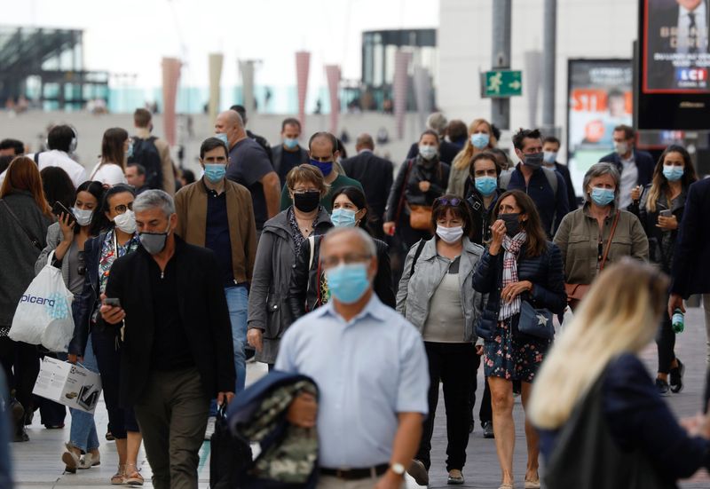 © Reuters. Masked people at financial and business district of La Defense