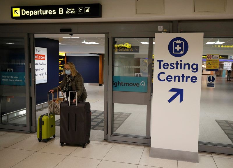 &copy; Reuters. FILE PHOTO:  A passenger walks past a testing centre sign in the terminal building of Manchester Airport amid the outbreak of the coronavirus disease (COVID-19) in Manchester