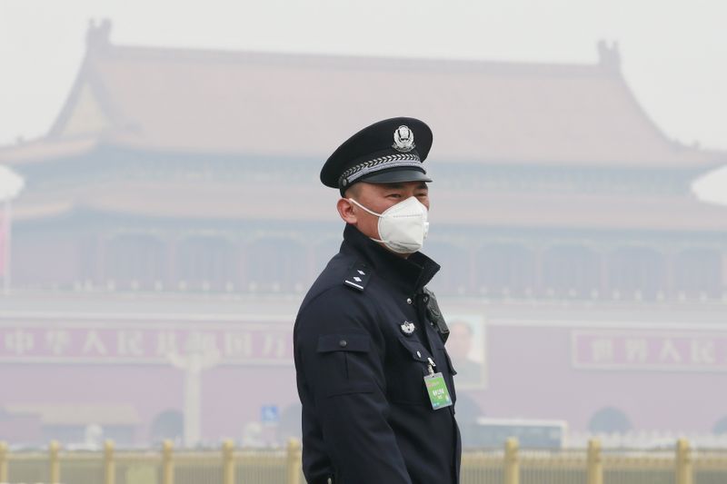 &copy; Reuters. A policeman, wearing a mask to protect from severe pollution, secures the area near the Great Hall of the People before the opening session of the Chinese People&apos;s Political Consultative Conference (CPPCC) in Beijing