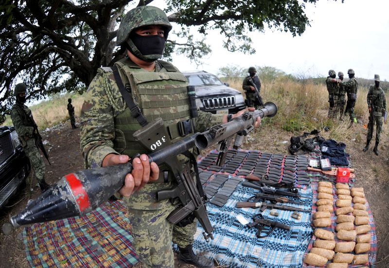 &copy; Reuters. FILE PHOTO: A soldier holds up a seized grenade launcher after an operation at the village of Guayabal