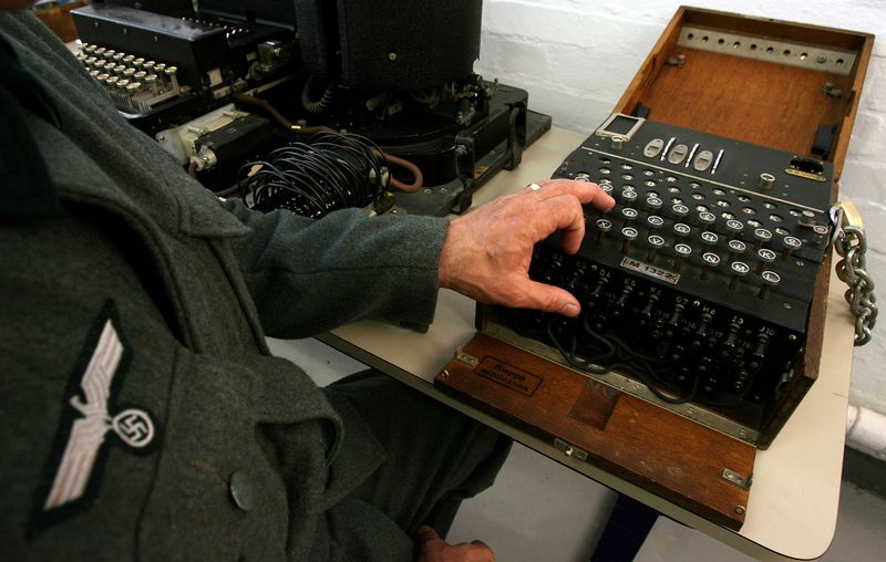 © Reuters. FILE PHOTO: Actor dressed as German soldier shows use of Enigma machine in Bletchley Park Museum