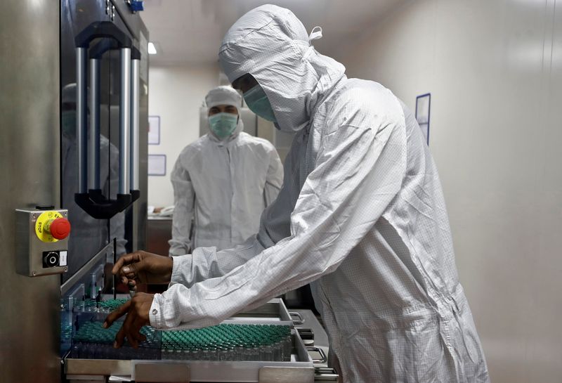 &copy; Reuters. FILE PHOTO: An employee in personal protective equipment (PPE) removes vials of AstraZeneca&apos;s COVISHIELD, coronavirus disease (COVID-19) vaccine, from a visual inspection machine inside a lab at Serum Institute of India, Pune