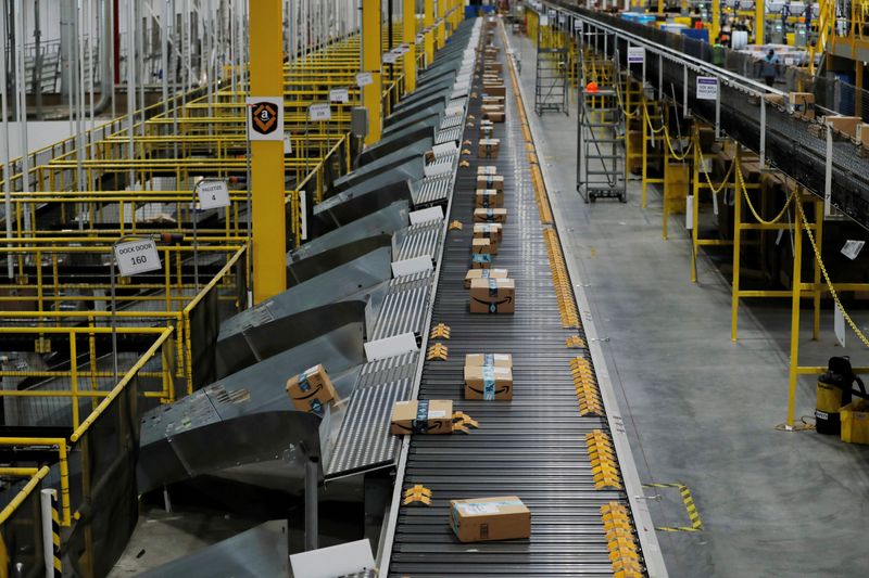 © Reuters. FILE PHOTO: Amazon packages are pushed onto ramps leading to delivery trucks by a robotic system as they travel on conveyor belts inside of an Amazon fulfillment center on Cyber Monday in Robbinsville, New Jersey