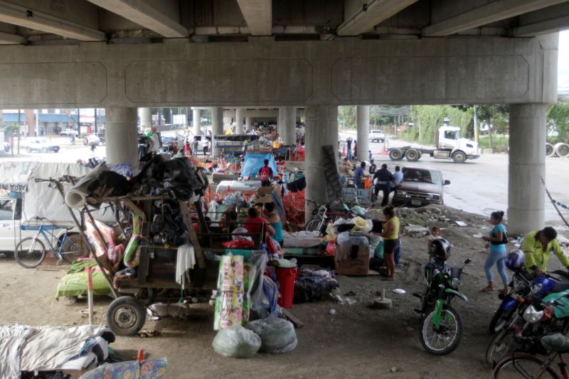 &copy; Reuters. A general view shows people and their belongings under an overpass, where they are sheltered along other residents that lost their homes due to the floods caused by heavy rain brought by Hurricane Iota, in San Pedro Sula