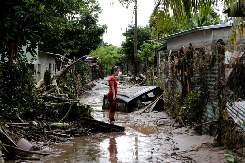 &copy; Reuters. A woman stands outside her home damaged due to heavy rains caused by Hurricane Eta, in Pimienta