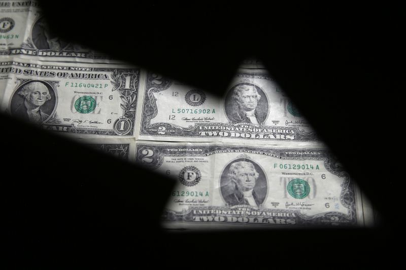 © Reuters. FILE PHOTO: Dollar banknotes are seen through printed stock graph in this illustration