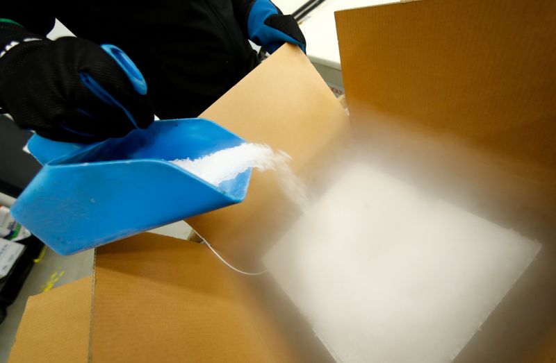 &copy; Reuters. An employee fills an ultra-low temperature container with dry ice to transport vaccines against the coronavirus disease (COVID-19) at a secret storage facility in the Rhein-Main area