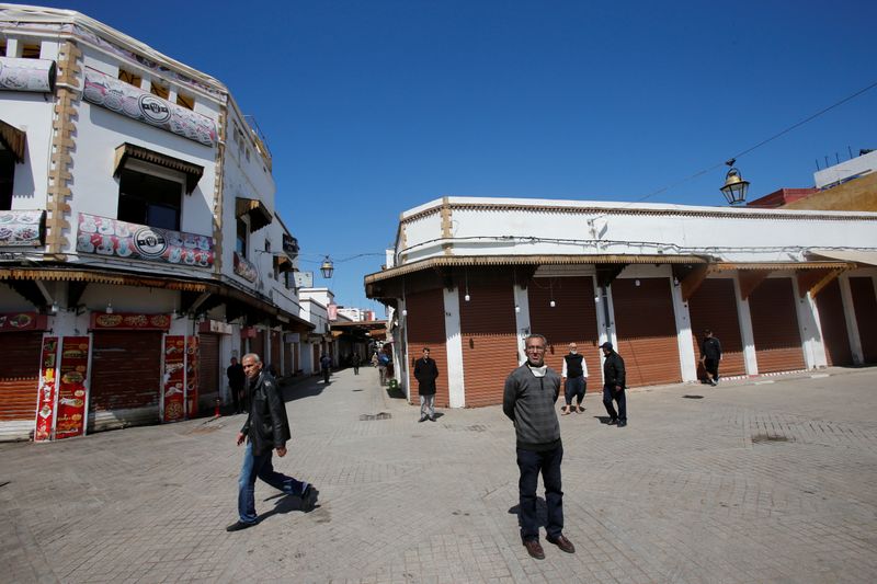 &copy; Reuters. FILE PHOTO: People stand near an empty street with closed shops in the old city, following the coronavirus disease (COVID-19) outbreak in Rabat,