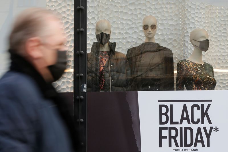 &copy; Reuters. A man wearing a protective mask walks past a shop window in central Kyiv