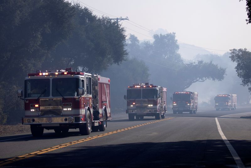 &copy; Reuters. FILE PHOTO:  Firefighters arrive to help fight the Bond Fire wildfire near Lake Irvine in Orange County, California