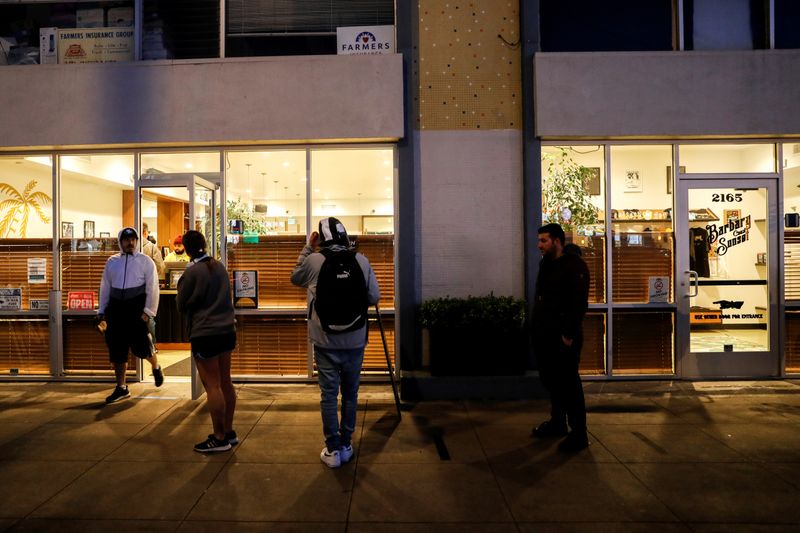 © Reuters. FILE PHOTO: People stand in line outside the Barbary Coast Sunset Cannabis Dispensary prior to the citywide shelter in place order amid the novel coronavirus (COVID-19) outbreak in San Francisco