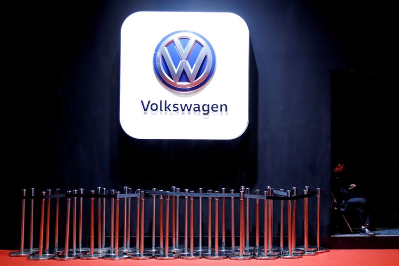 © Reuters. FILE PHOTO: Man uses phone under VW logo at the auto show in Shanghai