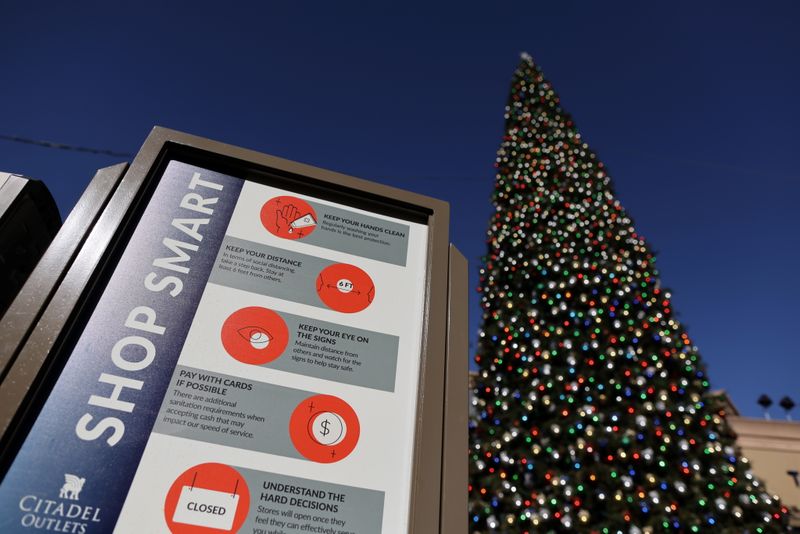 &copy; Reuters. A coronavirus advisory sign is seen in front of a Christmas tree at the Citadel Outlet mall, as the global outbreak of the coronavirus disease (COVID-19) continues, in Commerce