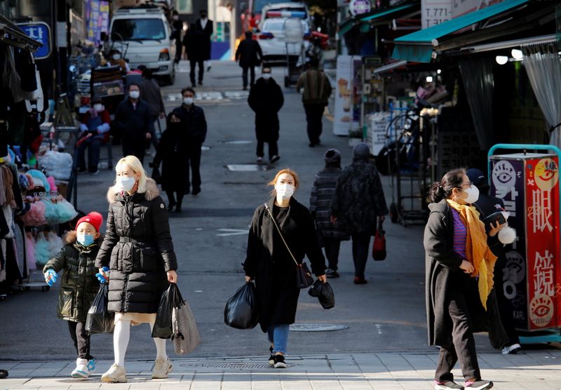&copy; Reuters. People wearing face masks walk at a traditional market amid the coronavirus disease (COVID-19) pandemic in Seoul